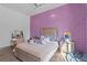 Charming bedroom with a plush bed, vanity area, purple accent wall, and soft natural light at 11734 Lake Willis Dr, Orlando, FL 32821
