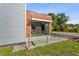 Modern home with glass enclosed entryway and partial metal and wood plank siding and landscaping at 11734 Lake Willis Dr, Orlando, FL 32821