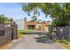 Modern home with wood and metal accents, featuring a long driveway and well-manicured landscaping at 11734 Lake Willis Dr, Orlando, FL 32821