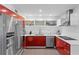 Stylish kitchen featuring red cabinets, stainless steel appliances, and modern lighting at 11734 Lake Willis Dr, Orlando, FL 32821