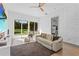 Bright living room featuring a modern textured wall, neutral sofa, and sliding glass doors to the backyard at 11734 Lake Willis Dr, Orlando, FL 32821