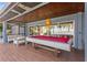 Spacious covered patio with a pool table and comfortable seating, perfect for outdoor entertainment with water views at 11734 Lake Willis Dr, Orlando, FL 32821