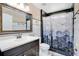 Well-lit bathroom featuring a vanity sink and a shower with a patterned curtain at 119 Hypolita Ave, Davenport, FL 33897