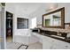 Bright bathroom featuring a soaking tub, vanity with black granite countertops, and a walk-in closet at 119 Hypolita Ave, Davenport, FL 33897