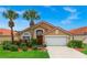 Charming single-story home with a red tile roof, lush landscaping, and a two-car garage at 119 Hypolita Ave, Davenport, FL 33897