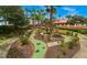 Lush mini golf course with vibrant green turf, landscaping, and mature palm trees at 119 Hypolita Ave, Davenport, FL 33897