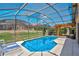 Relaxing screened-in pool area perfect for outdoor enjoyment with chairs and a grill at 119 Hypolita Ave, Davenport, FL 33897