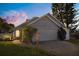 Charming single-Gathering home featuring a manicured front yard and a two-car garage at sunset at 121 Edgewater Cir, Sanford, FL 32773
