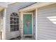 Stylish light blue front door with an decorative oval glass window, a 'Home' sign, and stone tile walkway at 121 Edgewater Cir, Sanford, FL 32773