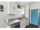 Bright kitchen features white cabinets, granite countertops, stainless steel appliances, and contrasting blue door at 121 Edgewater Cir, Sanford, FL 32773