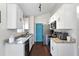 Kitchen with white cabinets, granite countertops, stainless steel appliances, hardwood floors and contrasting blue door at 121 Edgewater Cir, Sanford, FL 32773
