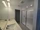 Bathroom featuring double sinks, modern glass shower, and bright lighting at 1243 Bear Oak Ln, Deland, FL 32720