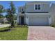 Charming two-story home with a well-manicured lawn and brick driveway at 1243 Bear Oak Ln, Deland, FL 32720