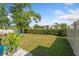 Large backyard with a swing set, green grass, and a privacy hedge at 12817 Parkbury Dr, Orlando, FL 32828