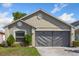 Exterior elevation of home featuring a two-car garage and manicured lawn at 12817 Parkbury Dr, Orlando, FL 32828