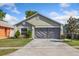 Charming one-story home featuring an attached two car garage, tidy landscaping, and neutral paint at 12817 Parkbury Dr, Orlando, FL 32828