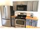 Kitchen featuring stainless steel appliances, gray cabinets, and butcher block countertops at 12817 Parkbury Dr, Orlando, FL 32828
