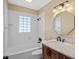 Bathroom with white tiled shower over tub and a wood vanity with white marble top and stylish mirror at 1333 W Yale St, Orlando, FL 32804