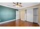 This bedroom is features a ceiling fan, baseboard trim, wood floor, painted accent wall and closet at 1333 W Yale St, Orlando, FL 32804