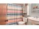 This cozy bathroom offers a sink with cabinet, a toilet, and a bathtub behind a decorative curtain at 1510 Jaguar Cir, Apopka, FL 32712