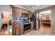A kitchen showcasing wood cabinets, stainless steel appliances, and views to the dining room and living room at 1510 Jaguar Cir, Apopka, FL 32712