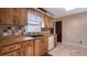 This kitchen features wood cabinetry, a colorful backsplash, tile flooring, and a black sink at 1510 Jaguar Cir, Apopka, FL 32712