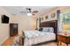 Comfortable bedroom featuring ceiling fan, two windows and a tv at 1510 Jaguar Cir, Apopka, FL 32712