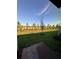 Backyard view showcasing a well-maintained lawn, mature trees, and a blue sky at 16464 Happy Eagle Dr, Clermont, FL 34714
