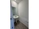 Half bathroom with a pedestal sink, stylish mirror, and tiled floor at 16464 Happy Eagle Dr, Clermont, FL 34714