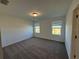 Spacious bedroom with neutral carpet and two windows offering outside views at 16464 Happy Eagle Dr, Clermont, FL 34714