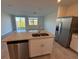 Well-lit kitchen featuring a center island, granite counters, stainless appliances, and an open-plan layout at 16464 Happy Eagle Dr, Clermont, FL 34714