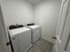 Efficient laundry room equipped with a white, front-load washer and dryer at 16464 Happy Eagle Dr, Clermont, FL 34714