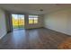 Bright living room featuring a sliding glass door, tiled floors, and ample natural light at 16464 Happy Eagle Dr, Clermont, FL 34714
