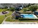 An aerial view of the community pool, playground, parking, and townhouses on a sunny day at 2016 Cypress Bay Blvd, Kissimmee, FL 34743