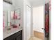 Bathroom with vanity, an adjacent closet and a bathroom behind a mirror cabinet at 2016 Cypress Bay Blvd, Kissimmee, FL 34743