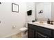 Well-lit half bathroom featuring a modern vanity, decorative mirror, and neutral color palette at 2016 Cypress Bay Blvd, Kissimmee, FL 34743
