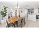 Open-concept dining room with modern lighting, seating for six, seamlessly connecting to the kitchen and living spaces at 2016 Cypress Bay Blvd, Kissimmee, FL 34743