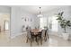 Bright dining room featuring a wooden table, stylish chairs, a decorative plant, and natural light from the windows at 2016 Cypress Bay Blvd, Kissimmee, FL 34743