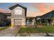 Charming two-story townhome with a well-manicured lawn, a brick driveway, and an attached garage at 2016 Cypress Bay Blvd, Kissimmee, FL 34743