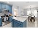 Well-lit kitchen with blue cabinets, stainless steel appliances, and an open view to the dining area at 2016 Cypress Bay Blvd, Kissimmee, FL 34743