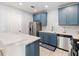 Stylish kitchen featuring blue cabinets, stainless steel appliances, and a breakfast bar, offering a modern design at 2016 Cypress Bay Blvd, Kissimmee, FL 34743