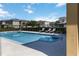 Inviting community pool with lounge chairs and neighborhood buildings under a bright sky at 2016 Cypress Bay Blvd, Kissimmee, FL 34743