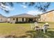 Spacious backyard featuring a brick fire pit and a covered patio, perfect for outdoor entertaining at 20335 Macon Pkwy, Orlando, FL 32833