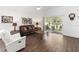 Bright living room featuring hardwood floors, a comfortable leather sofa, and sliding glass doors at 20335 Macon Pkwy, Orlando, FL 32833