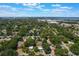 Aerial view showcases a neighborhood nestled among lush trees, with a picturesque lake in the distance at 219 Stribling Dr, Auburndale, FL 33823