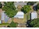 Bird's-eye view of a home with a metal roof, surrounded by lush greenery and a neatly kept lawn at 219 Stribling Dr, Auburndale, FL 33823