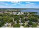 Aerial view of a neighborhood surrounded by a lake, featuring a mix of residential homes and mature trees at 219 Stribling Dr, Auburndale, FL 33823