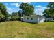 Exterior view showcasing a well-maintained backyard with healthy grass and a partially shaded patio at 219 Stribling Dr, Auburndale, FL 33823