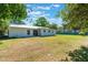 A well-maintained backyard showcases healthy grass, a concrete patio, and mature shade trees at 219 Stribling Dr, Auburndale, FL 33823