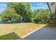 Expansive backyard featuring mature trees, healthy grass, and a concrete patio at 219 Stribling Dr, Auburndale, FL 33823